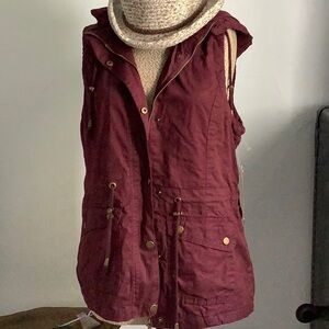 NWT burgundy color sleeveless jacket with hood. Size L